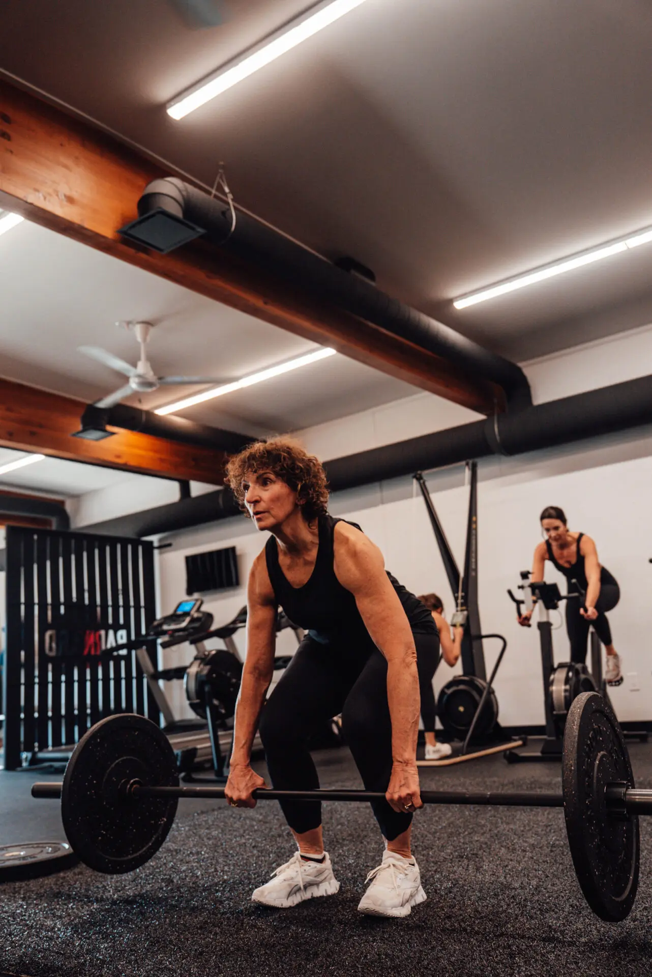 A girl with a trainer makes a swing with her foot