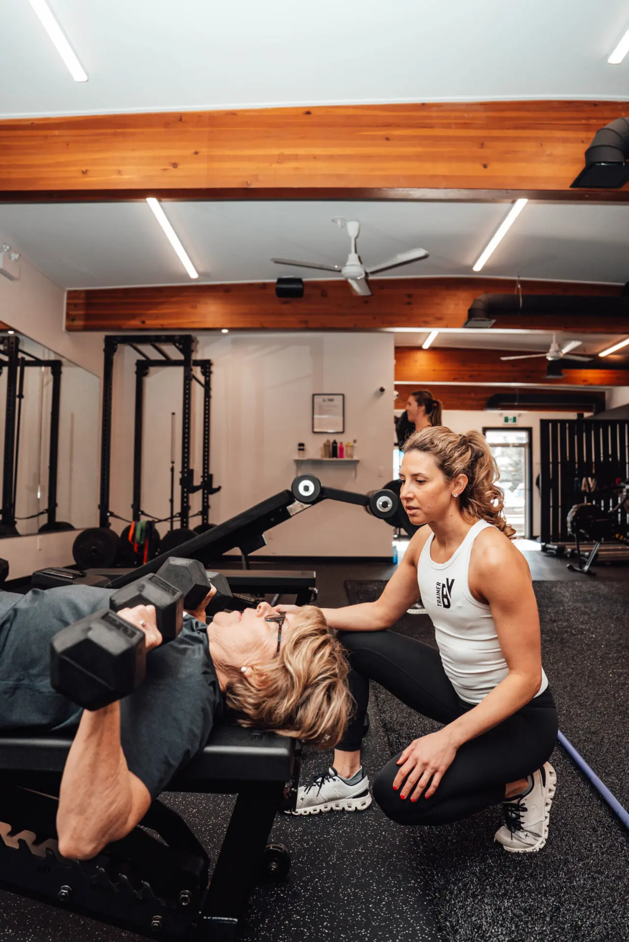 A girl with a trainer makes a swing with her foot